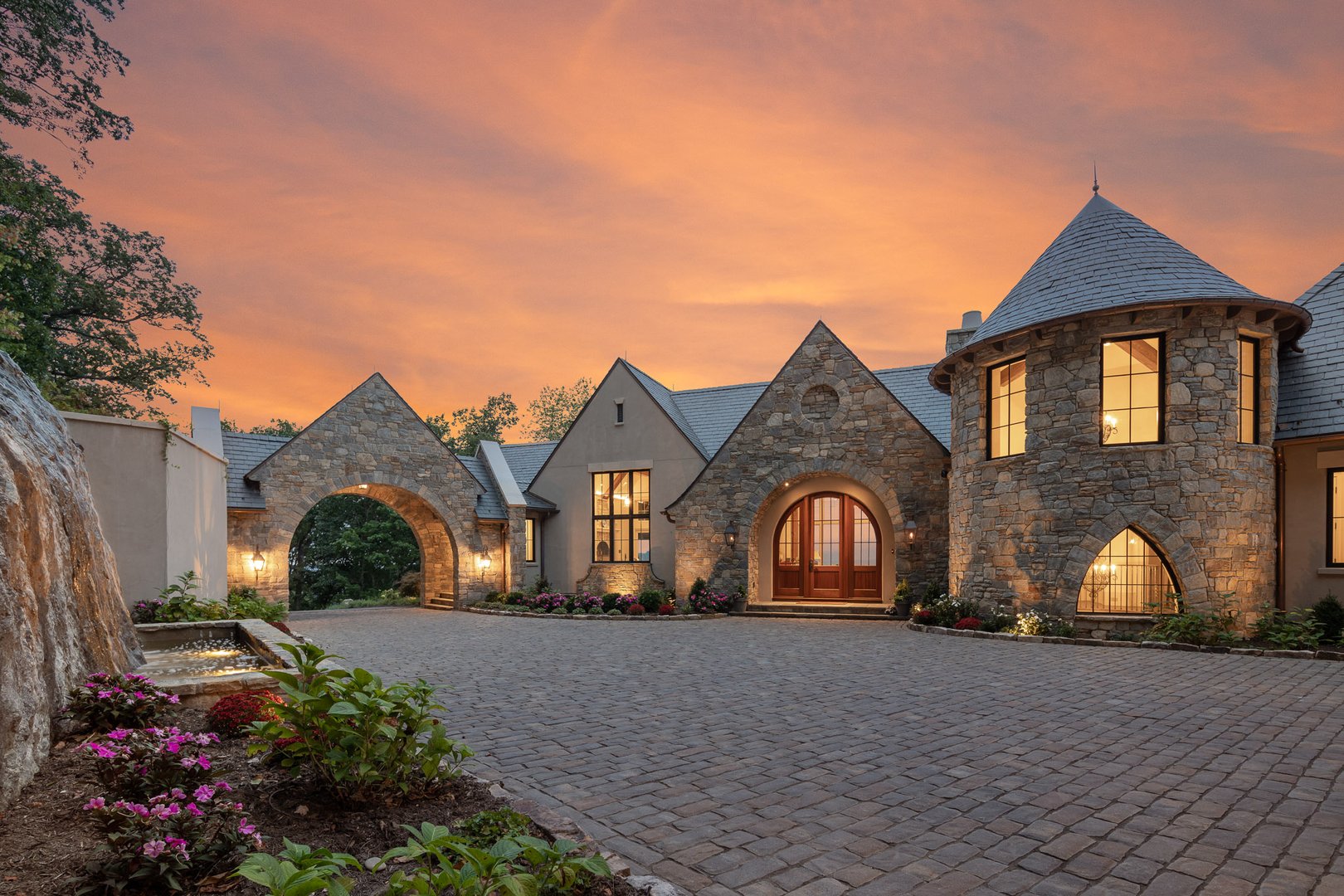 A beautiful home at dusk with stone facade, built by preferred builder Morgan-Keefe, located in The Cliffs at Walnut Cove.