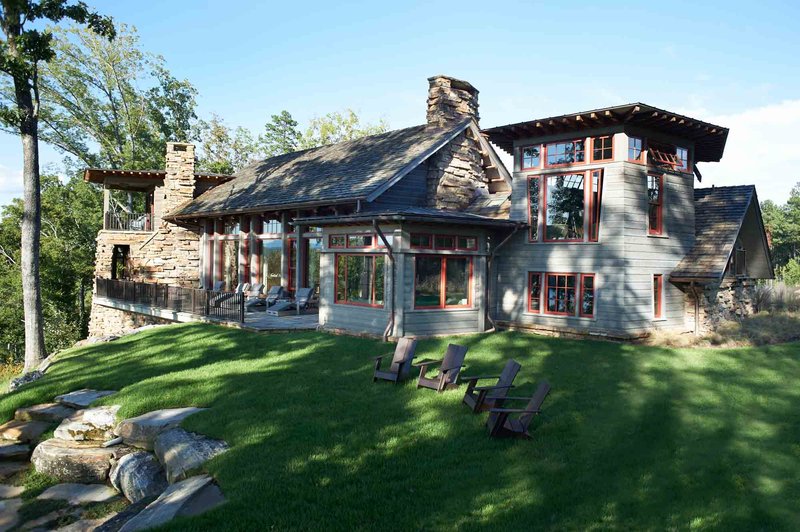 Beautiful grey home with red trim and stone chimneys